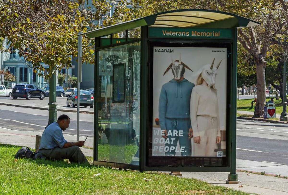 A man takes shelter from the sun as he waits for the bus in Oakland, Calif., on Monday, Sept. 5, 2022. Heat warnings and advisories have been extended until Thursday.