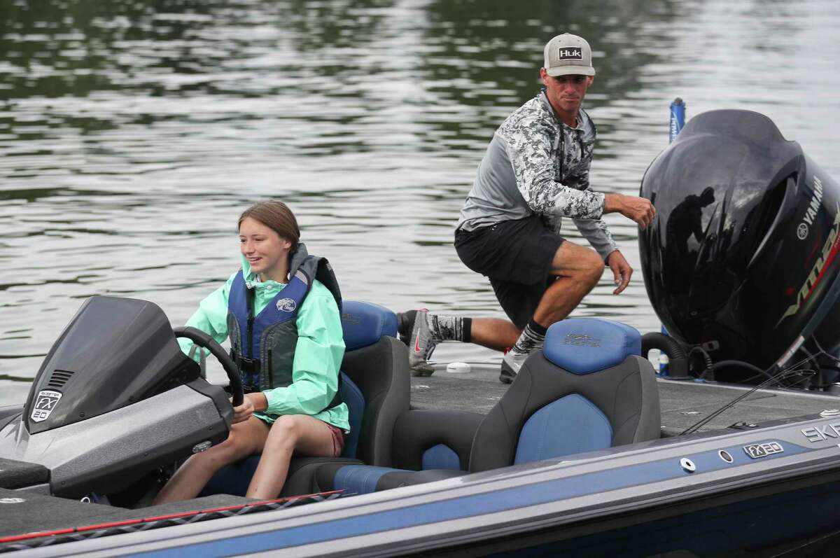 Cara Brown laughs as she forgets to take off a part to unblock the motor as she and her dad, Charlie, prepare to enjoy Labor Day weekend on their boat for a morning on fishing on Lake Conroe, Saturday, Sept. 3, 2022, in Conroe.
