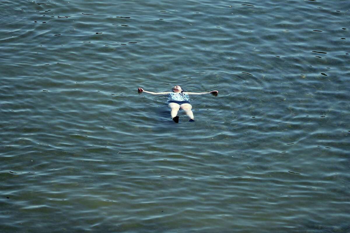 With a temperature of 111 degrees, a young woman cools off in the Russian River in Healdsburg, Calif., on Monday, Sept. 5, 2022.