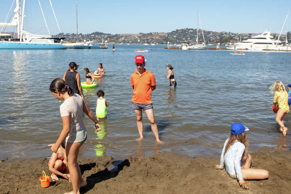 Aby się ochłodzić podczas fali upałów w San Francisco Bay Area, ludzie udają się do września.  5, 2022 zamknięte Sausalito Beach w Sausalito w Kalifornii.