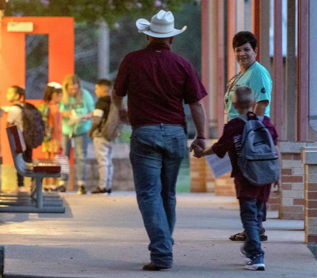 A child is walked to Uvalde Elementary on Tuesday, the first day of school for Uvalde CISD. The start of the 2022-2023 school year marked the first time students in the district had returned to classrooms since a gunman killed 19 children and two teachers in May.