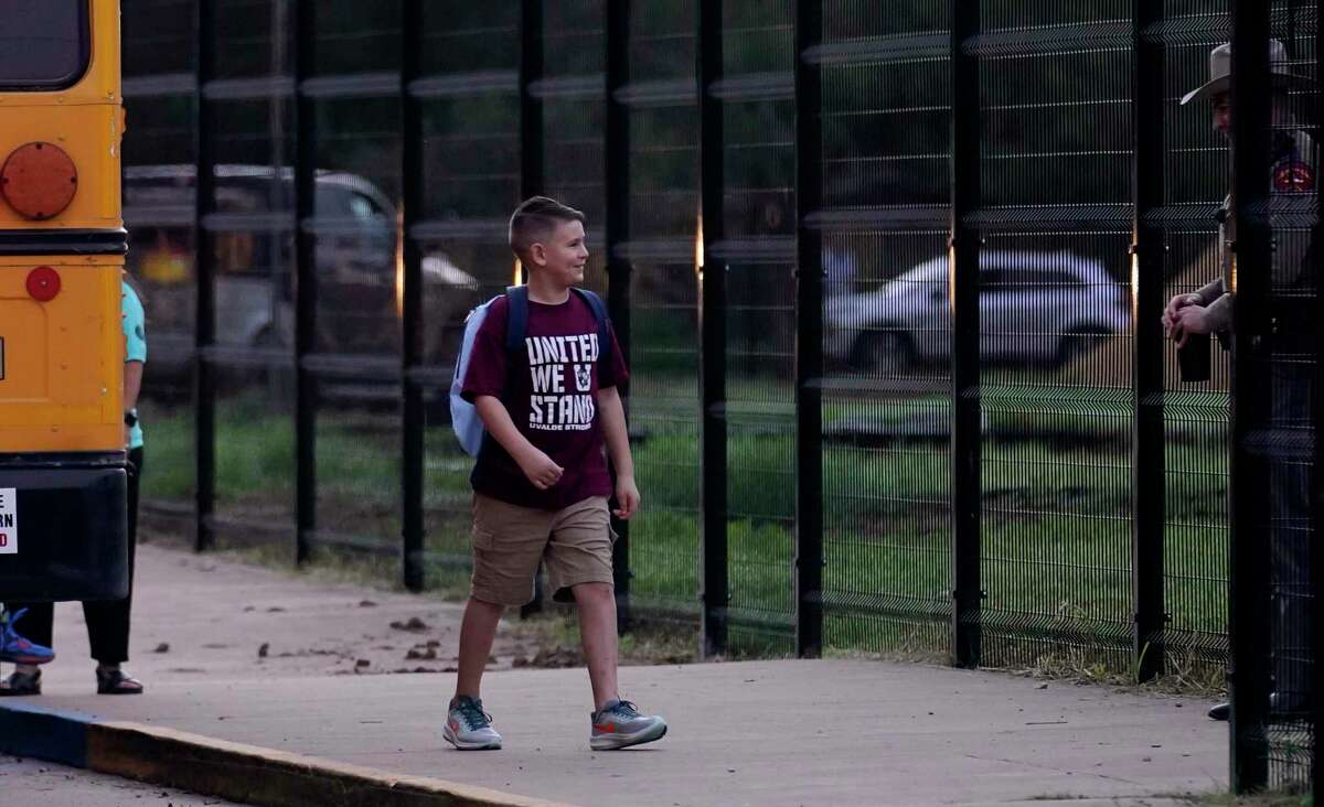 Students arrive at Uvalde Elementary School, now protected by a fence and Texas State Troopers, for the first day of school on Tuesday. Students are returning to campuses for the first time since the shootings at Robb Elementary School, where two teachers and 19 students were killed.