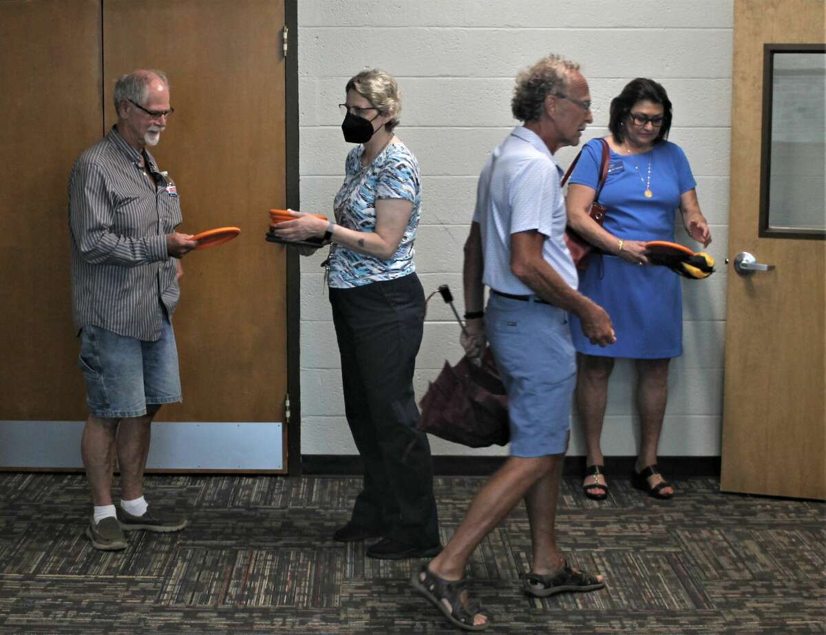 Ron Grew (left) receives a disc on Aug. 25 from Dianna Wall, Armory Youth Project fund development coordinator, during the Armory's disc golf sponsor appreciation party.