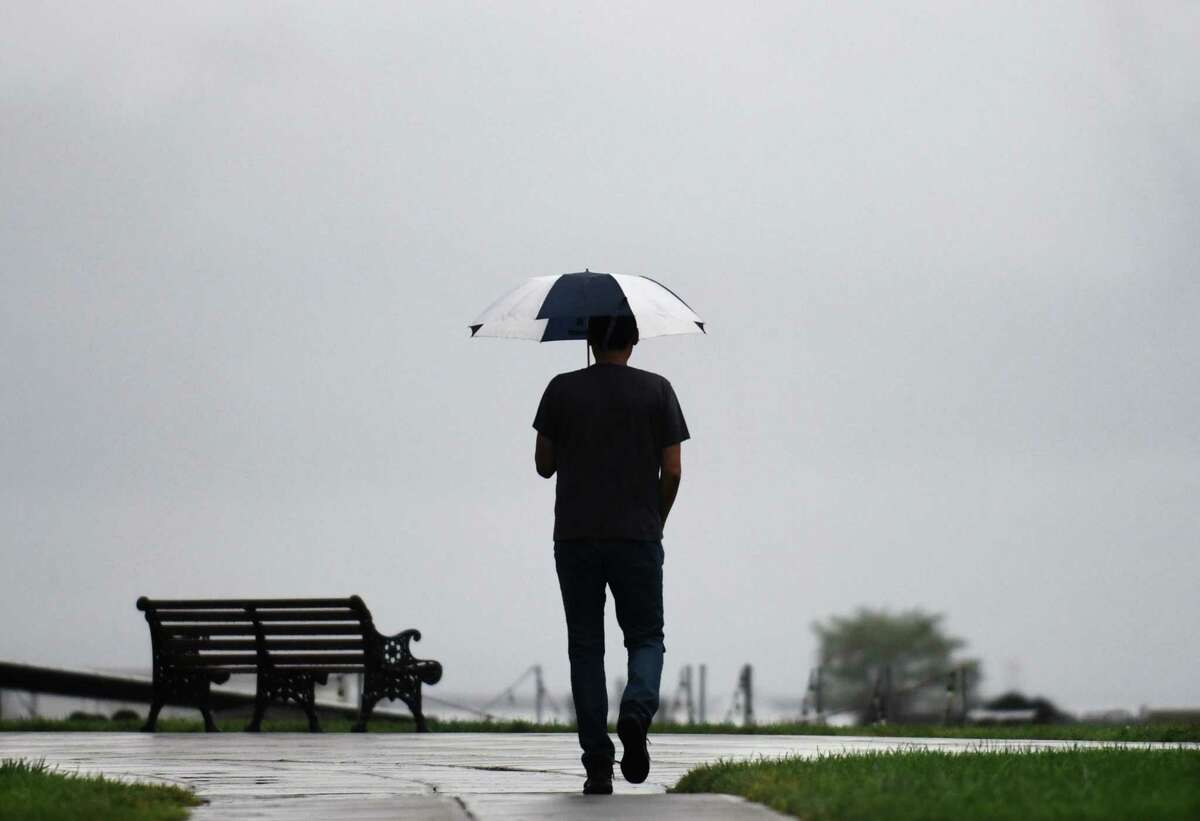 A man uses an umbrella to shield from the showers during a waterfront stroll through Harbor Point in Stamford, Conn. Tuesday, Sept. 6, 2022. Although the area got some much-needed rain on Tuesday, dry conditions with highs around 80 degrees are expected the rest of the week.