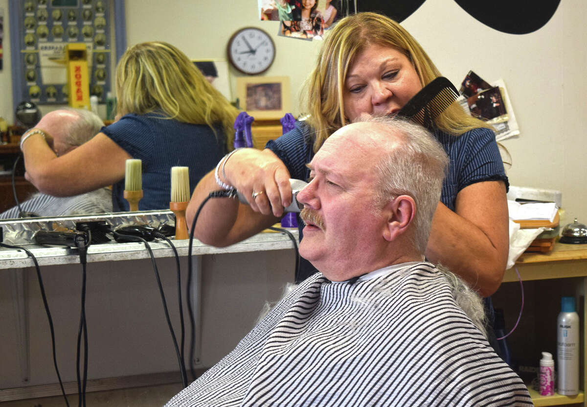Darrel Knox of Jacksonville gets a haircut from stylist Cindy Adams at Hair on the Square, 52 N. Central Park Plaza.