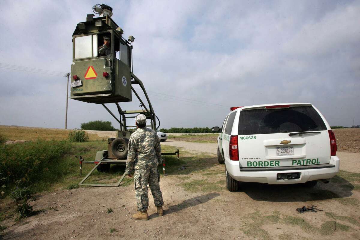 FILE - In this April 19, 2011 file photo, a member of the National Guard checks on his colleague inside a Border Patrol Skybox near the Hidalgo International Bridge in Hidalgo, Texas. If lawmakers in Austin have their way, the Texas National Guard will be staying at the border at a cost of $12 million. But is it worth it to have the guardsmen at the border? And what can they do, other than watch the brush, as the number of illegal immigrants crossing from Mexico continues to dwindle.(AP Photo/Delcia Lopez, File)