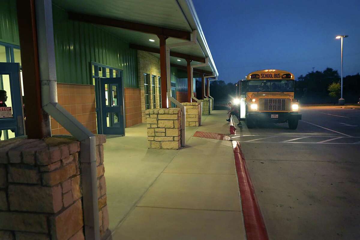 A student gets off a school bus at Rahe Bulverde Elementary School in the Comal Independent School District in 2015.
