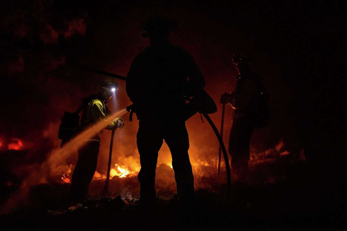 Firefighters put out a spot blaze as the Mill Fire burns in Lake Shastina (Siskiyou County).
