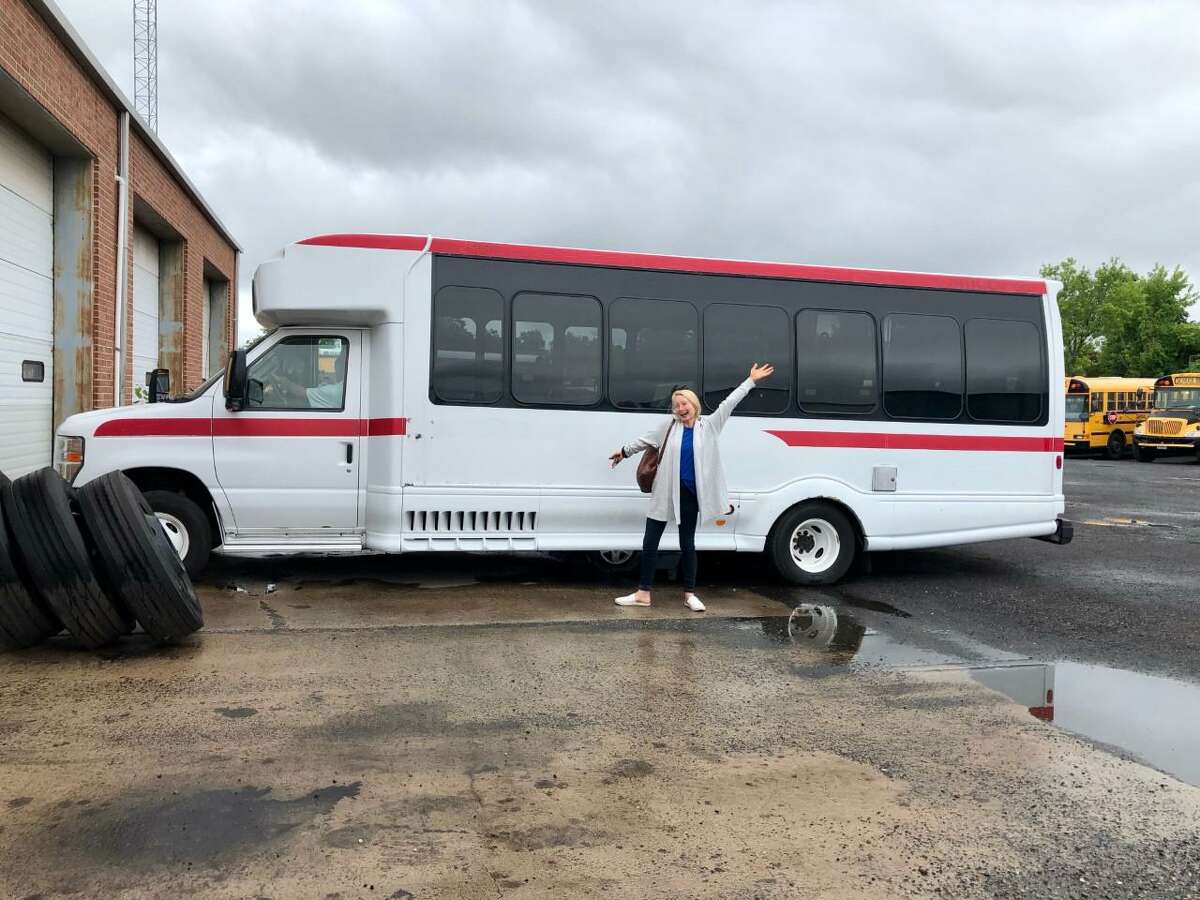 cARTie’s co-founder and Executive Director Clare Murray poses in 2021 with the recently acquired 20-foot bus which will become a mobile art education museum.