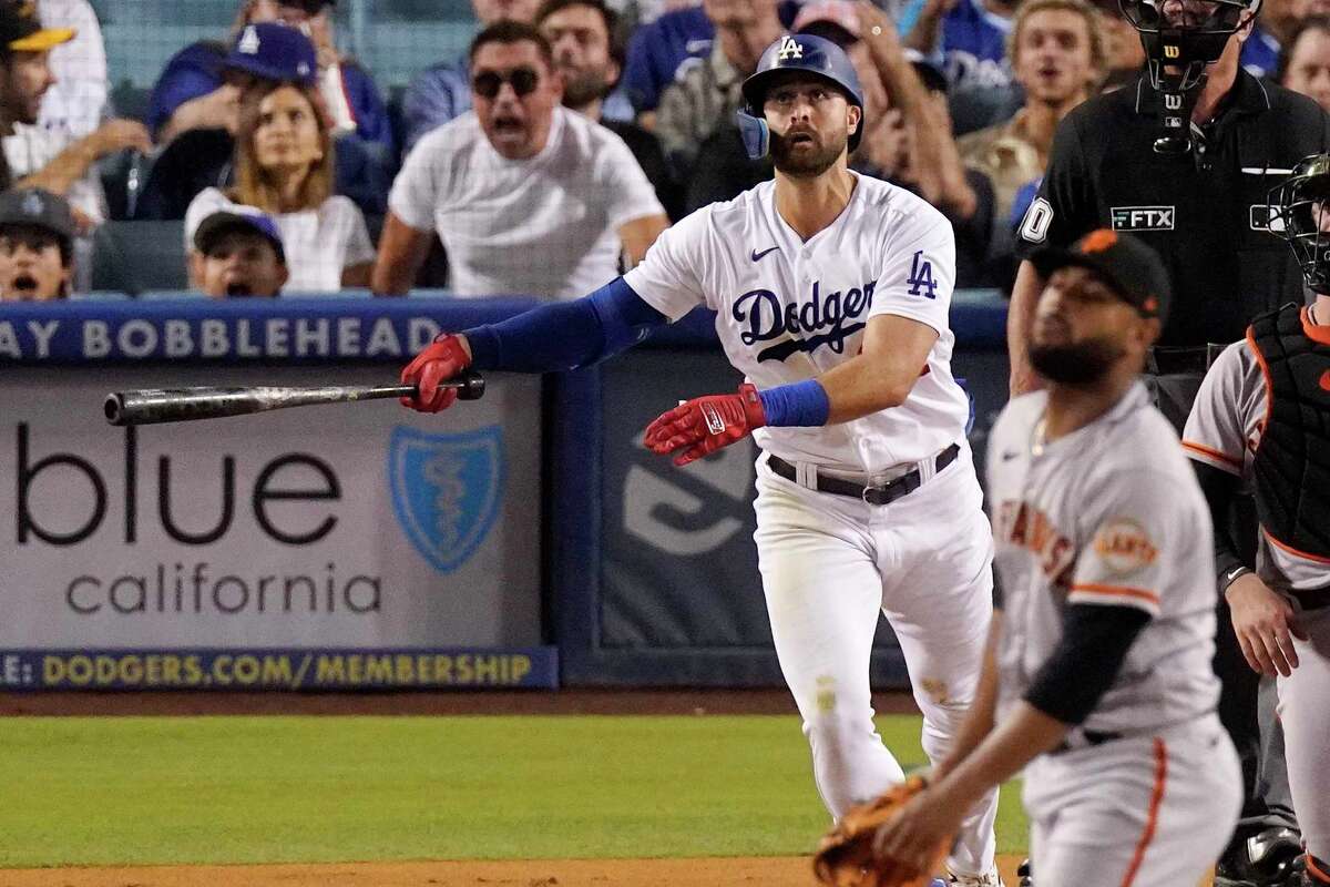 Los Angeles Dodgers' Joey Gallo, left, hits a three-run home run as San Francisco Giants relief pitcher Jarlin Garcia, right, watches during the second inning of a baseball game Tuesday, Sept. 6, 2022, in Los Angeles. (AP Photo/Mark J. Terrill)
