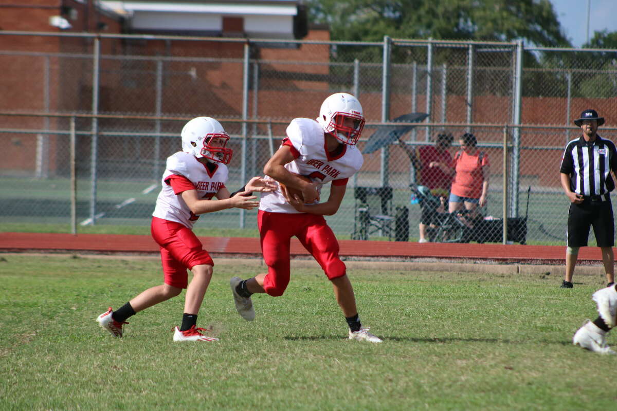 Deer Park Junior High quarterback Lian Kiefer finishes a handoff to Alexander Sablatura in the Fawns' season opener Tuesday that they won easily.