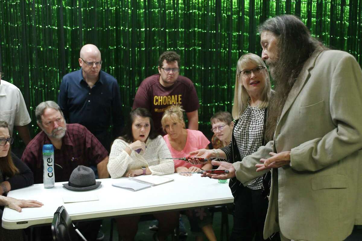 Juror No. 3, played by David Schultz of Pearland, standing left, glowers as jurors portrayed by Deborah Winters Cheney and Marvin Byrkett show evidence in a scene from "12 Angry Jurors" at Purple Box Theater.