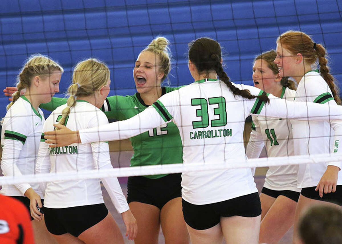 Carrollton libero Abby Flowers (green jersey) gathers in her Hawks to celebrate a point in a match earlier this season at the Roxana Tourney. On Tuesday, the Hawks celebrated their first three-set victory of the season at Carlinville.