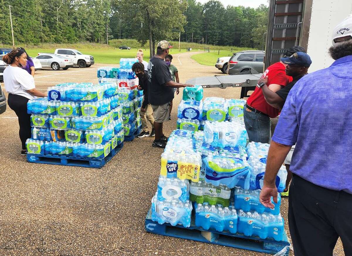 Members of God’s Haven, a faith-based charitable organization in Jackson, Mississippi, distribute bottled water on Saturday morning that was provided by Edwardsville American Legion Post 199.
