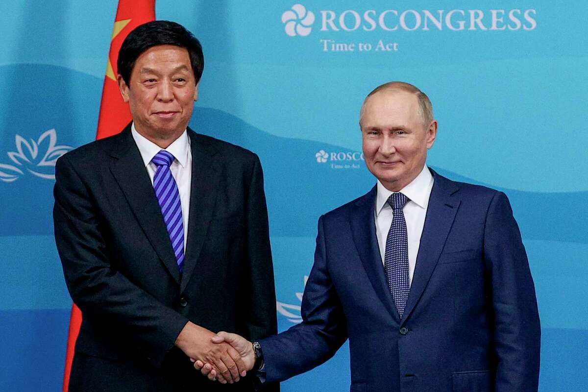 Russian President Vladimir Putin, right, and Chairman of National People's Congress Li Zhanshu pose for a photo prior to their talks on the sideline of the Eastern Economic Forum in Vladivostok, Russia, Wednesday, Sept. 7, 2022.