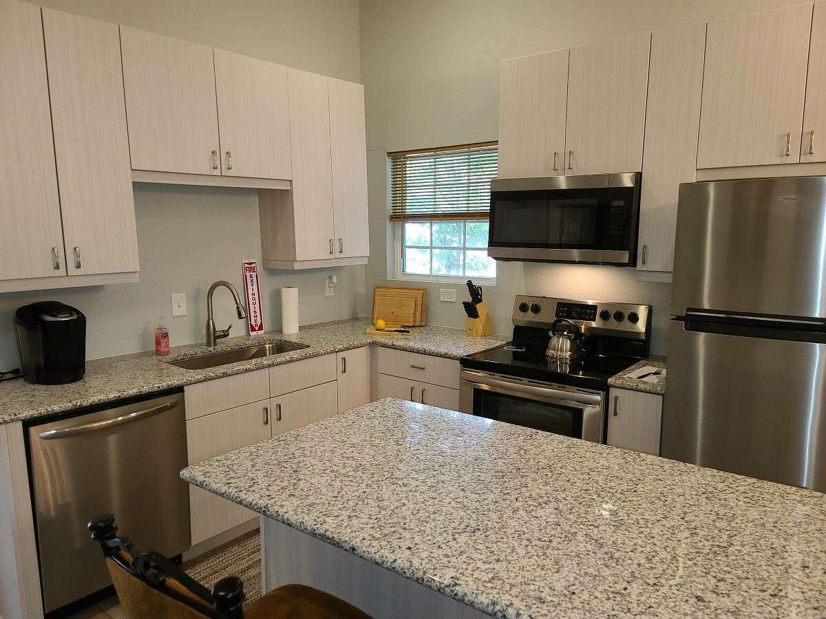 The kitchen has been updated with stone countertops and stainless steel appliances.