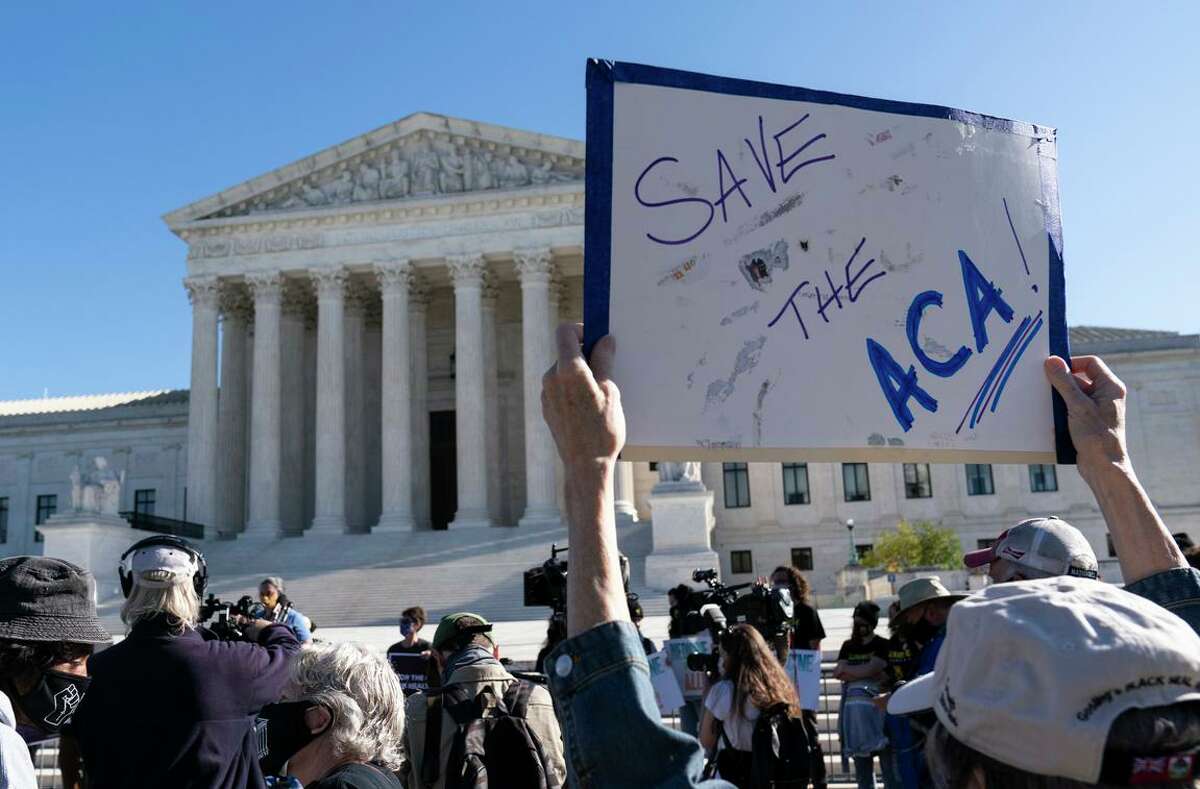 A demonstrator holds a sign in front of the U.S. Supreme Court as arguments are heard in a case involving the Affordable Care Act in 2020.