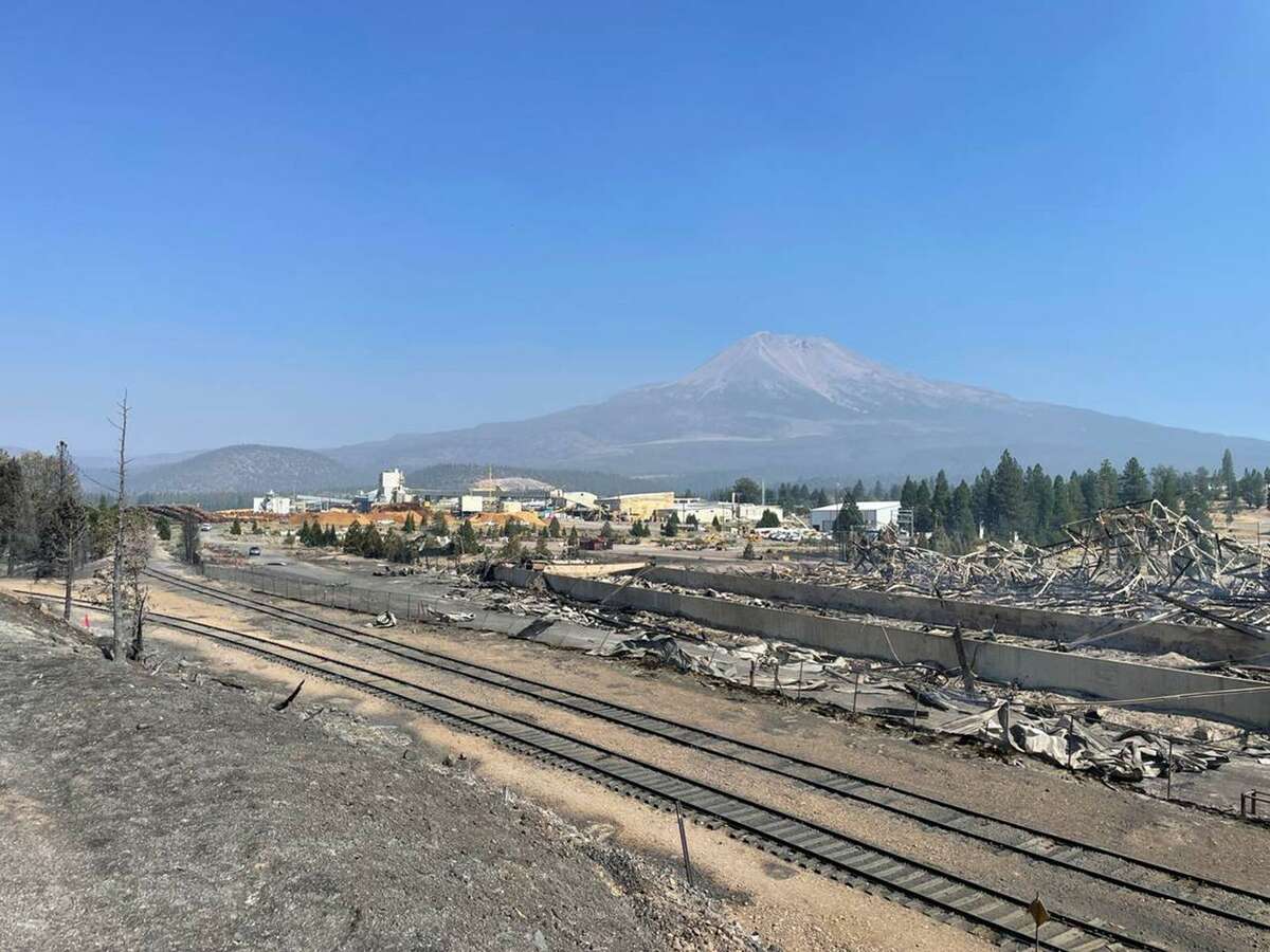 A destroyed warehouse smolders Saturday, Sept. 3, 2022, on Roseburg Forest Products property in Weed, California, one day after the Mill fire burned through the adjacent Lincoln Heights neighborhood. (Ryan Sabalow/Sacramento Bee)