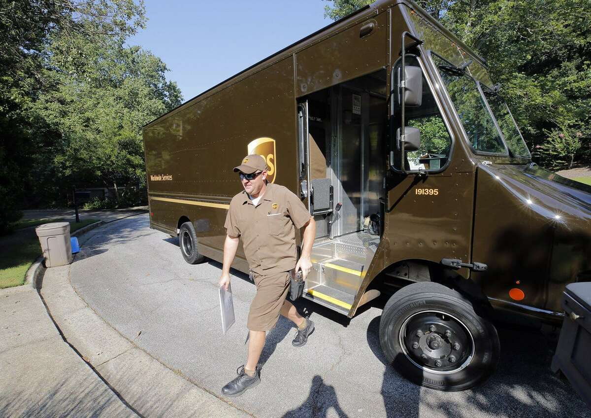 Driver Dan Partyka delivers an overnight package last year. As more people buy more goods online, the rapid and unrelenting expansion of e-commerce is causing real challenges for UPS. (Bob Andres/Atlanta Journal-Constitution/TNS)