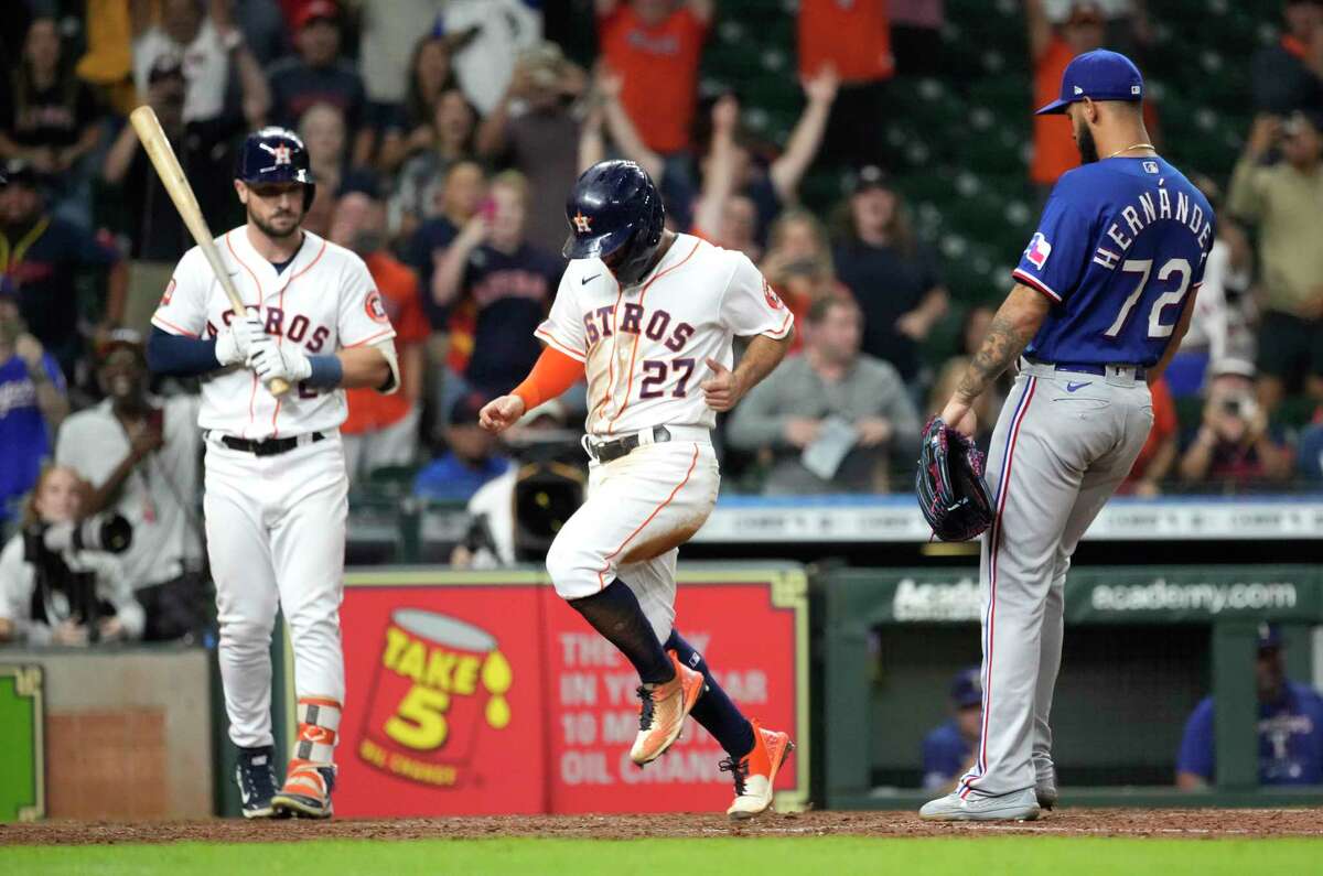 Jose Altuve races home with the winning run after a wild pitch by Rangers reliever Jonathan Hernandez during the 10th inning Wednesday at Minute Maid Park.