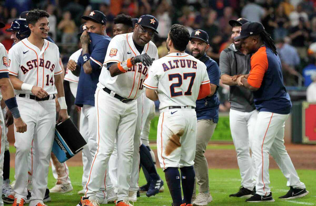 Houston Astros manager Dusty Baker Jr. (12) celebrates with Jose Altuve (27) after he scored a run on a wild pitch by Texas Rangers relief pitcher Jonathan Hernandez (72) to win the game 4-3 during an MLB baseball game at Minute Maid Park on Wednesday, Sept. 7, 2022 in Houston.