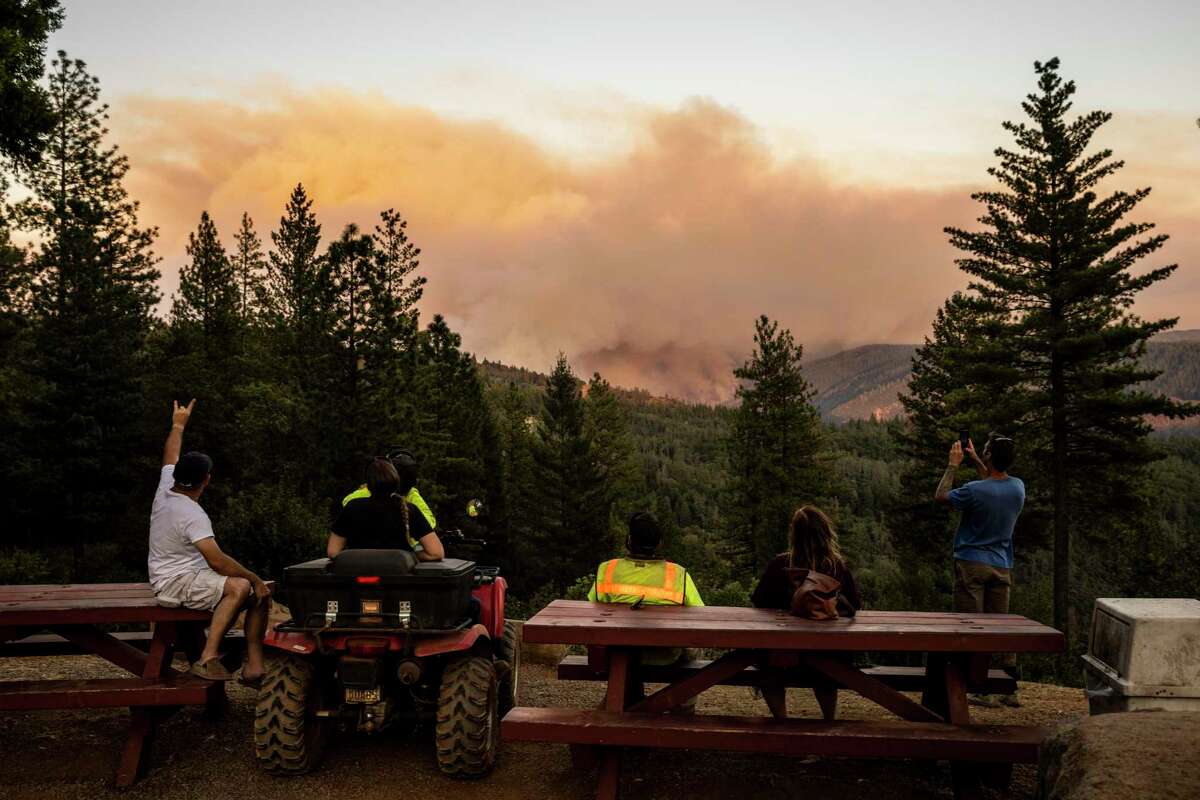 People watch from a distance as the Mosquito Fire burns near Michigan Bluff in unincorporated Placer County, Calif. Wednesday, Sept. 7, 2022.