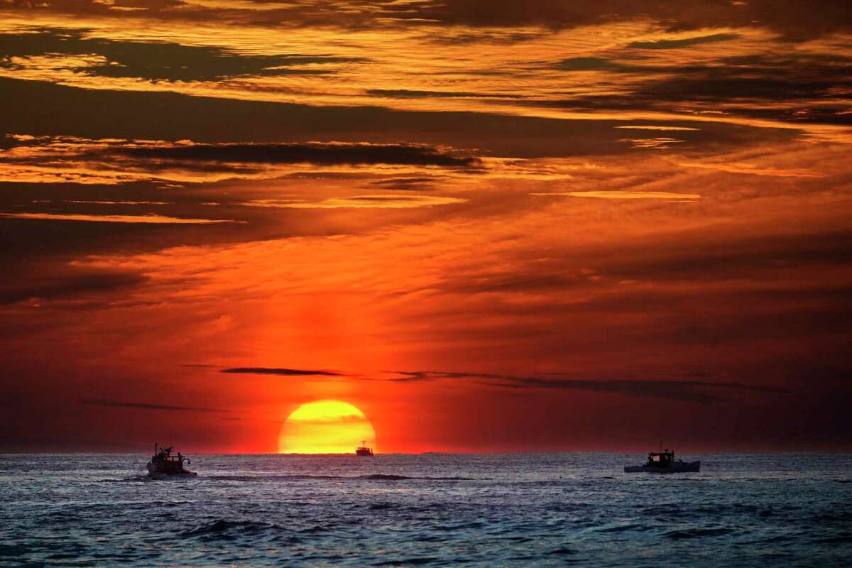 Lobster fishermen are already at work as the sun rises over the Atlantic Ocean, Thursday, Sept. 8, 2022, off of Kennebunkport, Maine. (AP Phot6o/Robert F. Bukaty)
