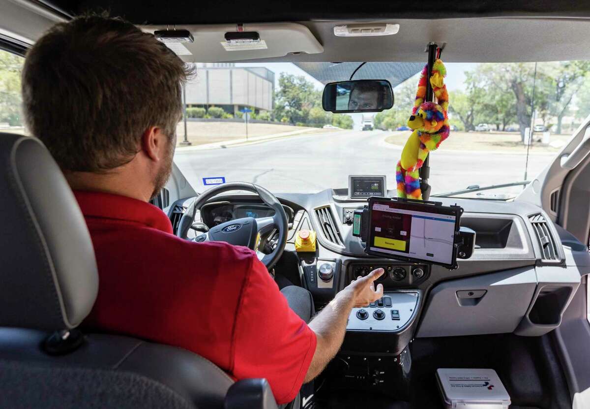 Alexander Youngs, a senior research engineer at Southwest Research Institute, sits in the driver’s seat with his hands off the steering wheel during a demonstration of the institute’s self-driving shuttle bus on Aug. 3. The vehicle navigates using a combination of images of the road underneath it and light detection and ranging — or lidar — to sense its surroundings.