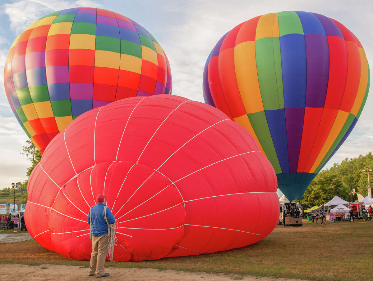 A Re/Max crew member helps keep the crown line taut during inflation at the Hudson Valley Hot Air Balloon Festival.