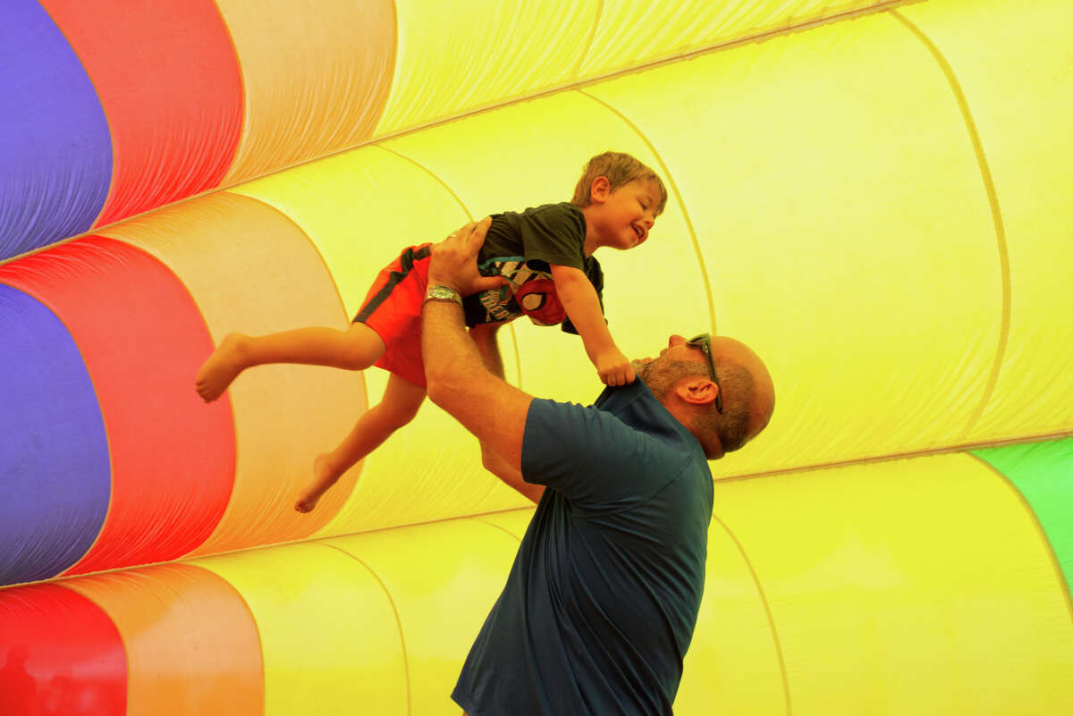 A father throws his son into the air during the Balloon Walk experience at the Hudson Valley Hot Air Balloon Festival on Saturday September 3, 2022 in Tymor Park.