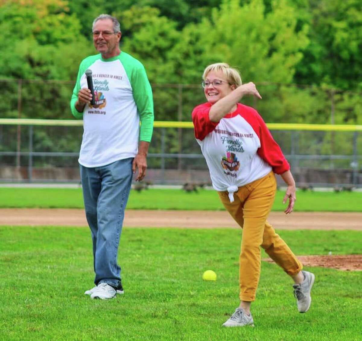 Torrington Mayor Elinor Carbone, pictured with Friendly Hands Food Bank board President Danny Harnett, throws the first pitch for Homeruns 4 the Hungry, a softball game to benefit the food bank Wednesday.
