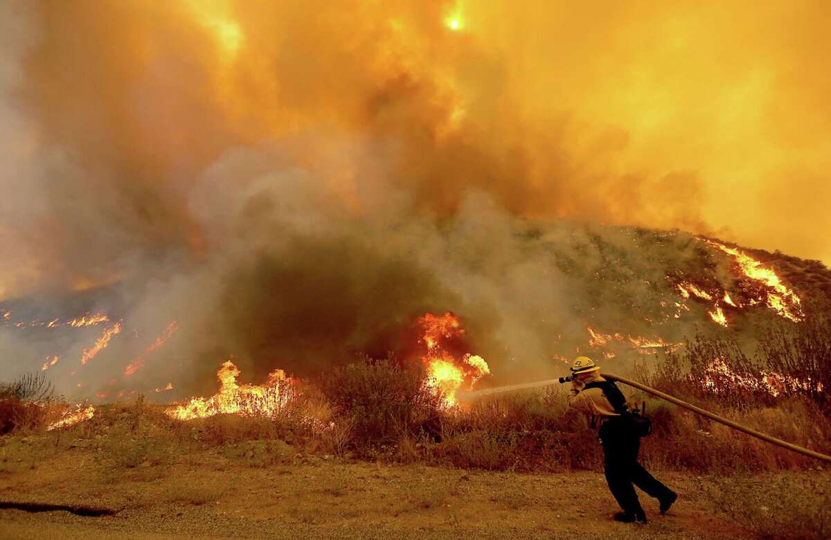 A firefighter battles the Fairview fire near Hemet, California, on Tuesday, Sep. 6, 2022.