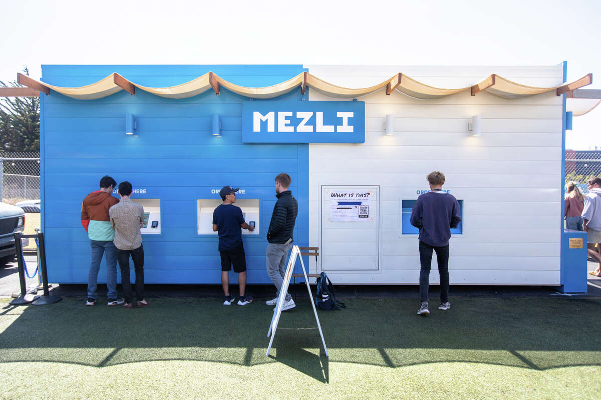 Customers place orders at Melzi, an entirely-robot run restaurant serving Mediterranean grain bowls at Spark Social San Francisco on Sept. 2, 2022.