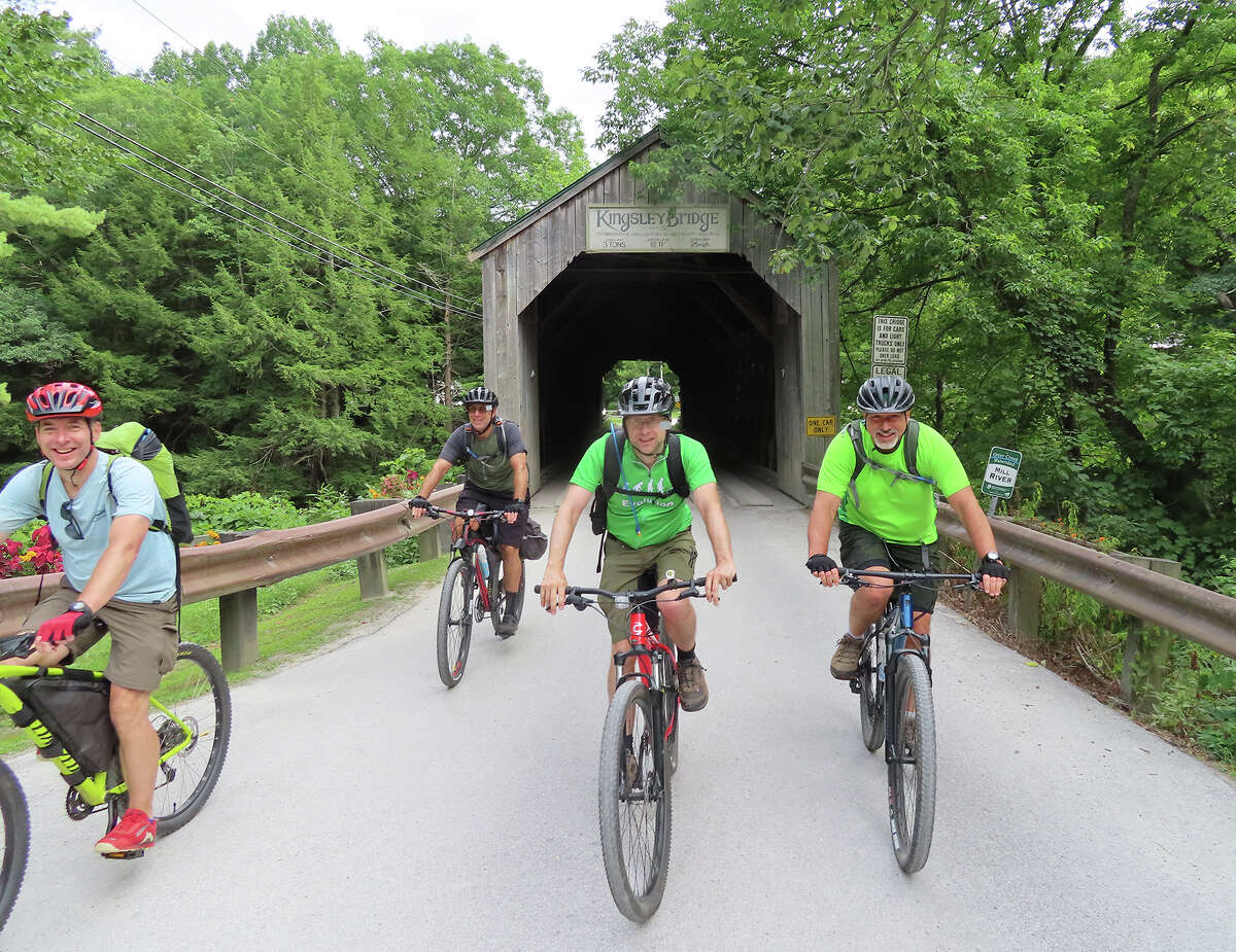 Herb Terns, left, and his cycling buddies ride out from the Kingsley Cover Bridge in Clarendon, Vt.