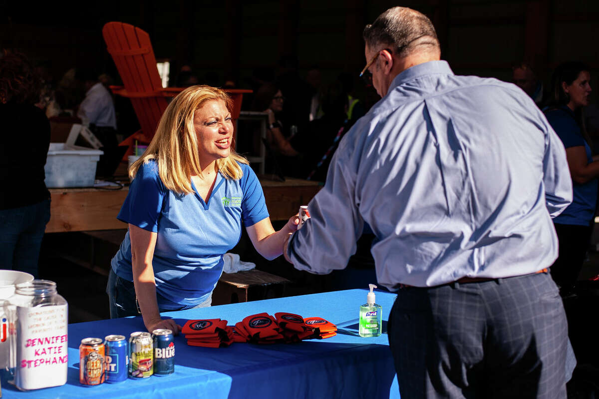 Midland County Habitat for Humanity President and CEO Jennifer Chapple serves alcohol at the organization's House Party fundraiser on Sept. 8, 2022 at the Greater Michigan Construction Academy.