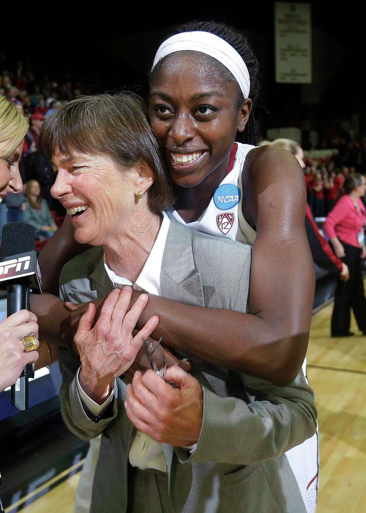 Stanford coach Tara VanDerveer is hugged by forward Chiney Ogwumike, rear, during an interview after a regional final against North Carolina in the NCAA women's college basketball tournament in Stanford, Calif., Tuesday, April 1, 2014. Stanford won 74-65. (AP Photo/Marcio Jose Sanchez)