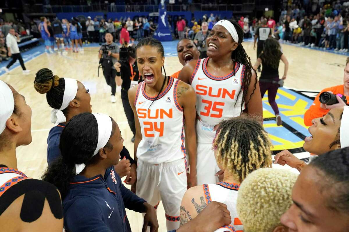 Connecticut Sun's DeWanna Bonner (24) and Jonquel Jones celebrate with teammates after their win over the Chicago Sky after Game 5 in a WNBA basketball playoff semifinal Thursday, Sept. 8, 2022, in Chicago. (AP Photo/Charles Rex Arbogast)