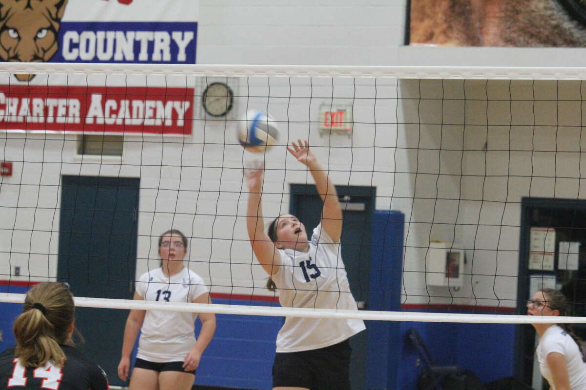 Crossroads' Alexis Carr (15) works at getting the ball over the net against  Mesick on Thursday.