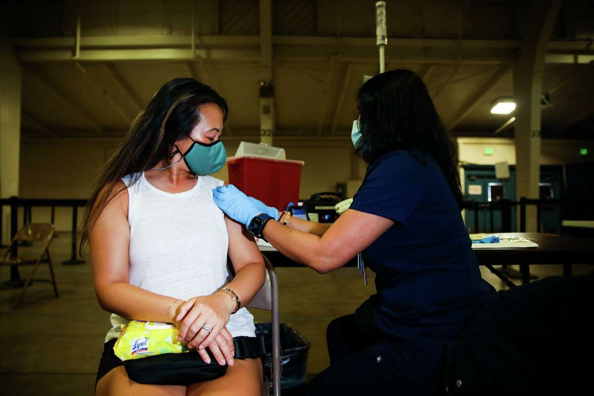 Jessie Ho, 41, of Fremont, gets the Pfizer booster shot at the Santa Clara County Fairgrounds in San Jose, Calif. 