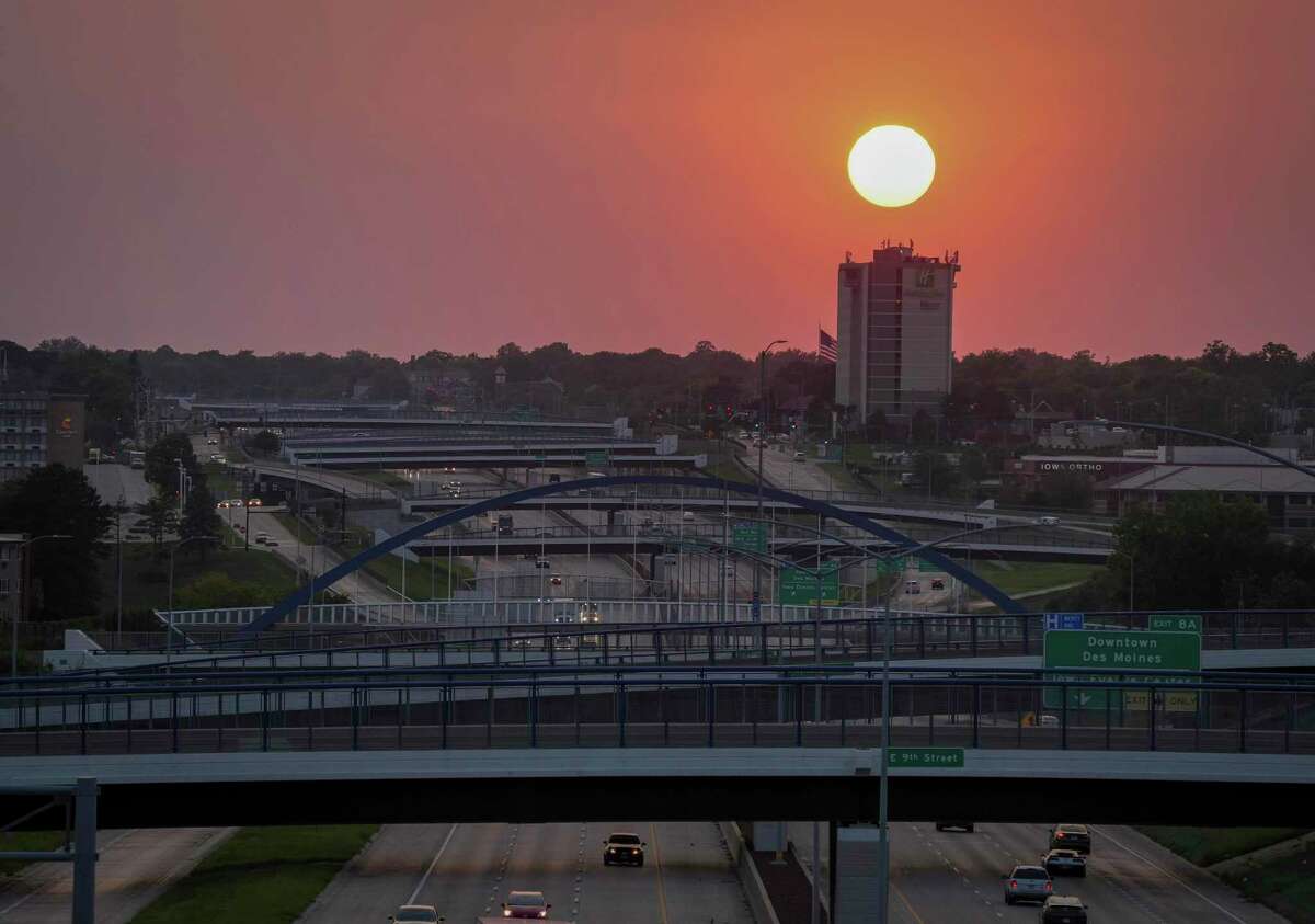 The sun glows red as it sets over Des Moines, Iowa, on Thursday, Sept. 8, 2022. Smoke from the wildfires in California is causing the sunsets to appear reddish. Meteorologist Garry Lesser said the conditions may produce “more robust” sunrises, moonrises and sunsets in Connecticut this weekend.