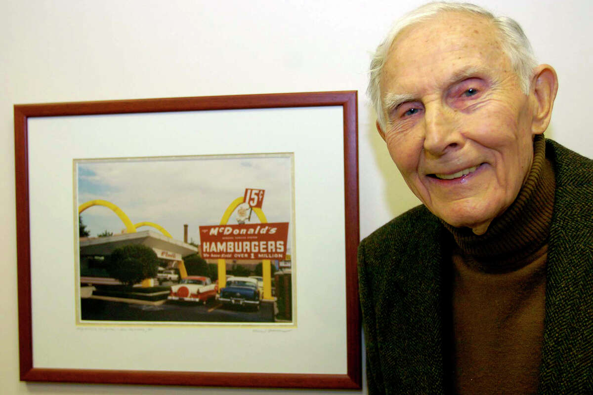 Lou Groen, owner of the Stop Tech Co., in Harrison, Ohio, stands next to a photo of the McDonalds restaurant in Dent, Ohio, that he use to own in 1962, in his office Feb. 6, 2007, in Harrison. The restaurant was where the first Fish sandwich was made by Groen. Groen has since sold the restaurant but still lives in the area. (AP Photo/The Enquirer, Ernest Coleman)