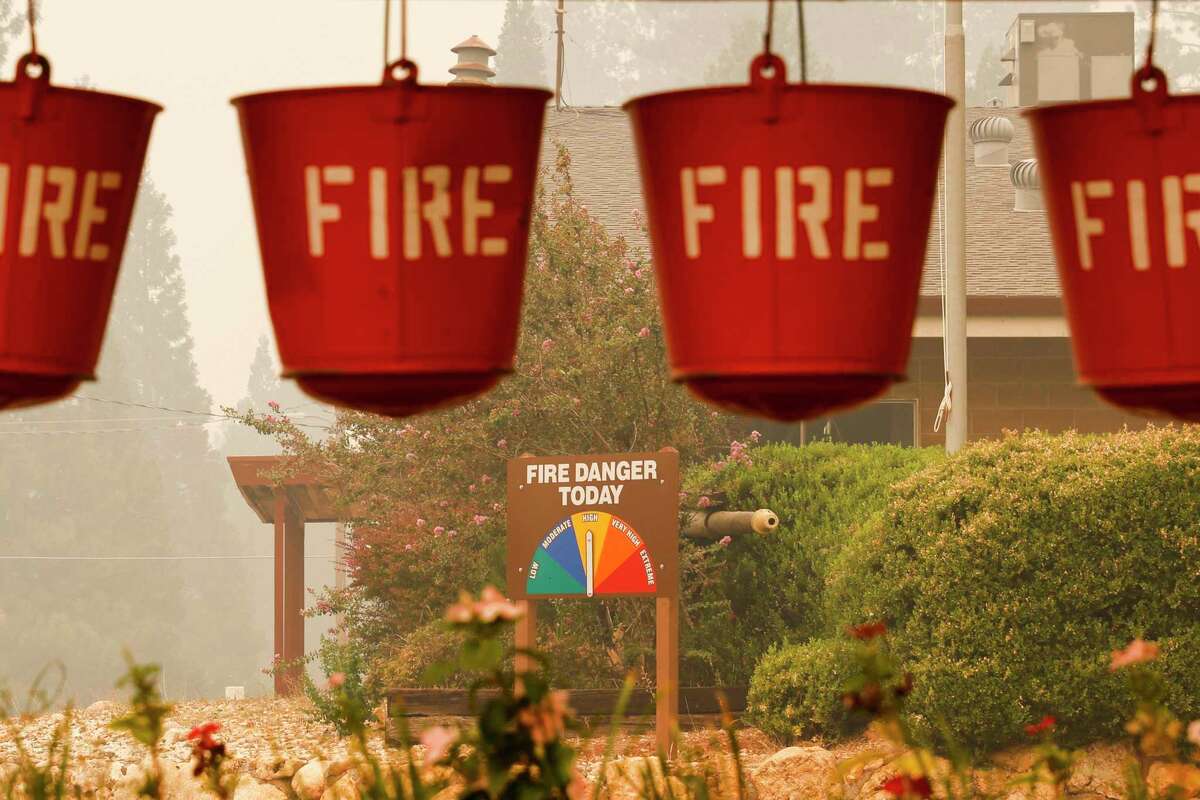 A sign shows the level of fire danger as smoke from the Mosquito Fire fills downtown Foresthill in September.