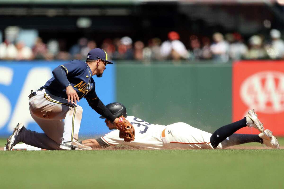 San Francisco Giants’ Thairo Estrada steals second base as Milwaukee Brewers’ Willy Adames applies a late tag in 7th inning during MLB game at Oracle Park in San Francisco, Calif., on Sunday, July 17, 2022.