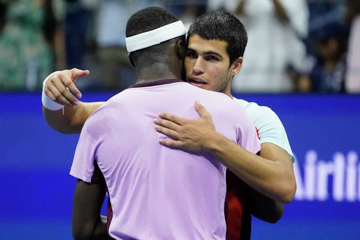 Carlos Alcaraz, of Spain, right, hangs Frances Tiafoe, of the United States, after winning their semifinal match of the U.S. Open tennis championships, Friday, Sept. 9, 2022, in New York.