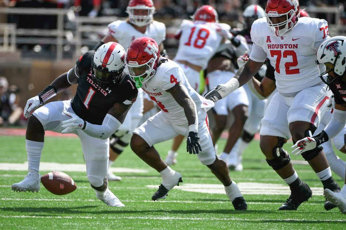 Houston running back Ta'Zhawn Henry (4) and Texas Tech linebacker Krishon Merriweather (1) go after a ball fumbled by Henry during the first half of an NCAA college football game Saturday, Sept. 10, 2022, in Houston. (AP Photo/Justin Rex)