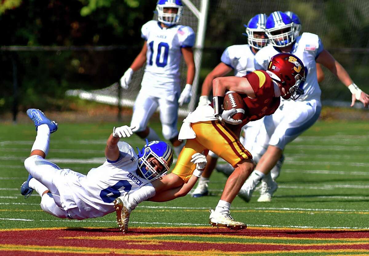 Darien's Briggs McGuckin (6) tries to tackle St. Joseph's Brandon Hutchinson (1) as he carries the ball during football action in Trumbull, Conn., on Saturday September 10, 2022.