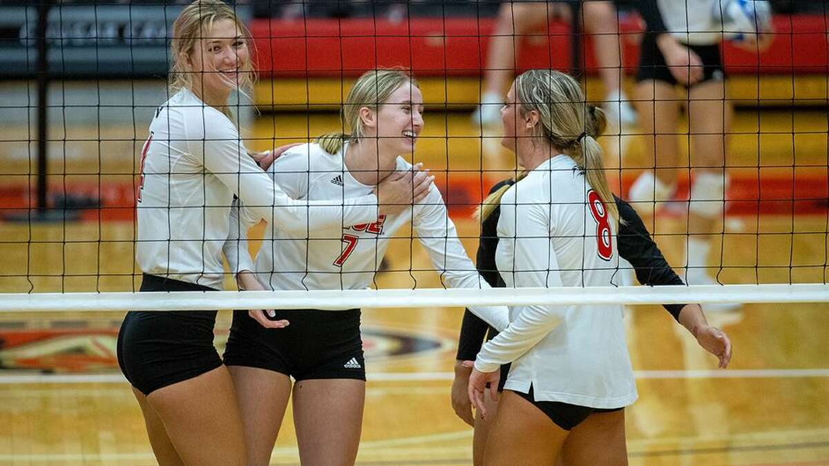 Members of the SIUE volleyball team talk at the net before play during a home match in Edwardsville.