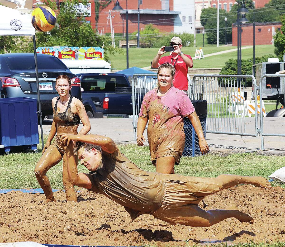 John Badman|The Telegraph Brandon Torrez, from the Ace Holes team, dives for the volleyball Saturday on the first day of the mud volleyball tournament at the Alton Expo. The location of the mud pits was moved closer to the Alton Marina this year and the mud was going through a break in phase with some of it super thick at the start of play. Everybody seemed to enjoy the games which went on most of Saturday. The tournament, sponsored by the Alton Sports Tap, continued Sunday.