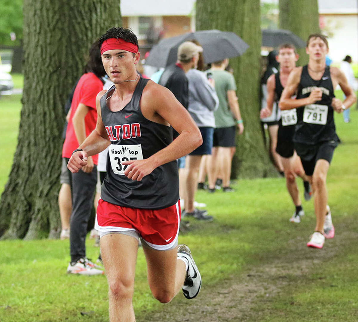 Alton senior Simon McClaine (left) runs during the Granite City Invite on Sept. 3. On Saturday at the Belleville West Invitational, McClaine ran ninth to help the Redbirds to a third-place finish.