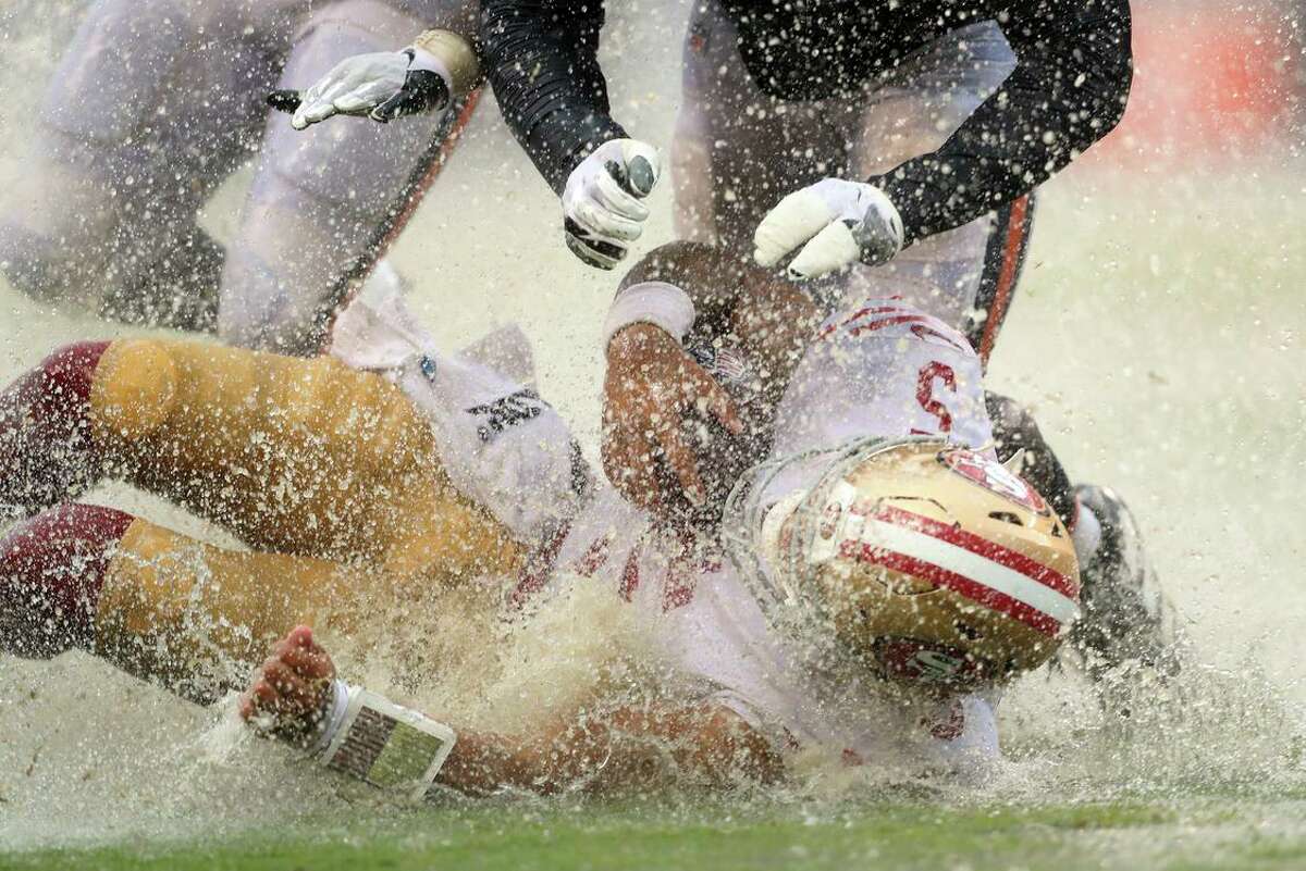 San Francisco 49ers’ Trey Lance slides in the rain in the Fourth quarter of the Niners’ 19-10 loss to the Chicago Bears at Soldier Field.